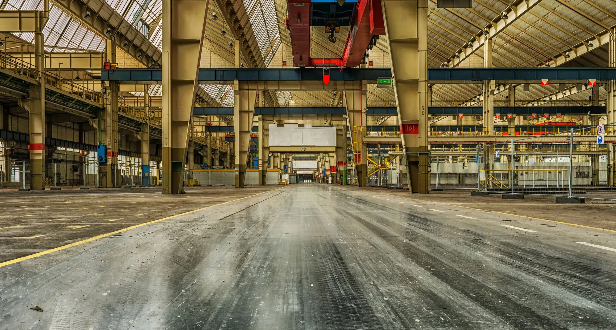 Interior de una gran nave industrial con estructura metálica vista