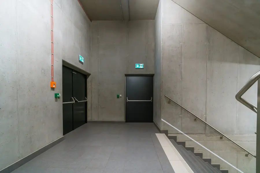 Escalera protegida de hormigón con señalización de evacuación